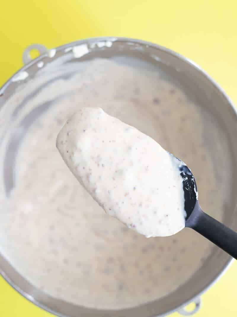 Spoonful of Black Cake Ice Cream mixture showing fruit bits in creamy base.