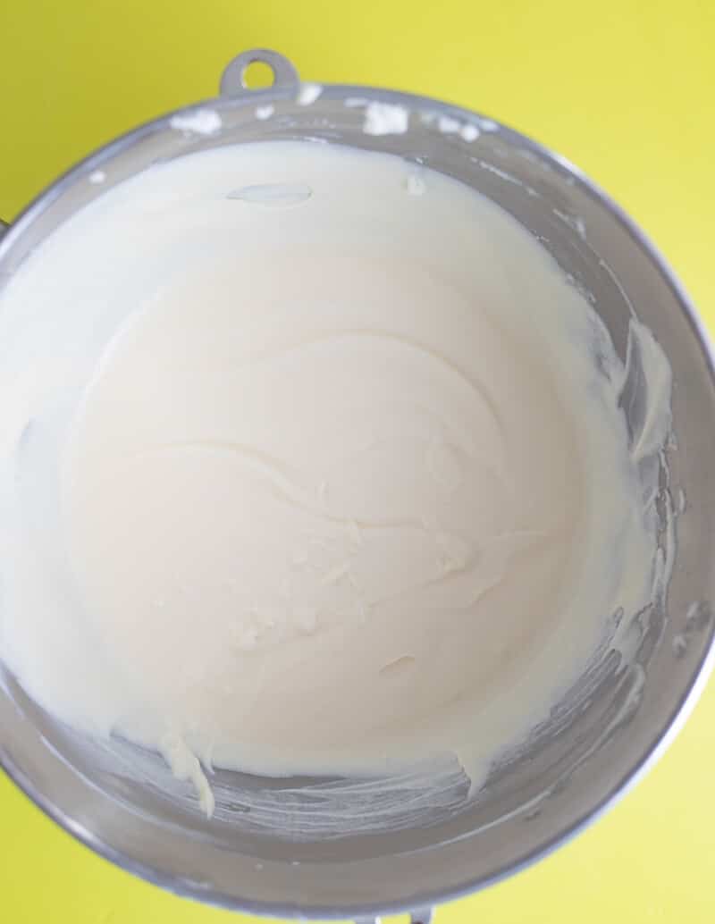 Mixing condensed milk with whipped cream for no-churn Black Cake Ice Cream base.