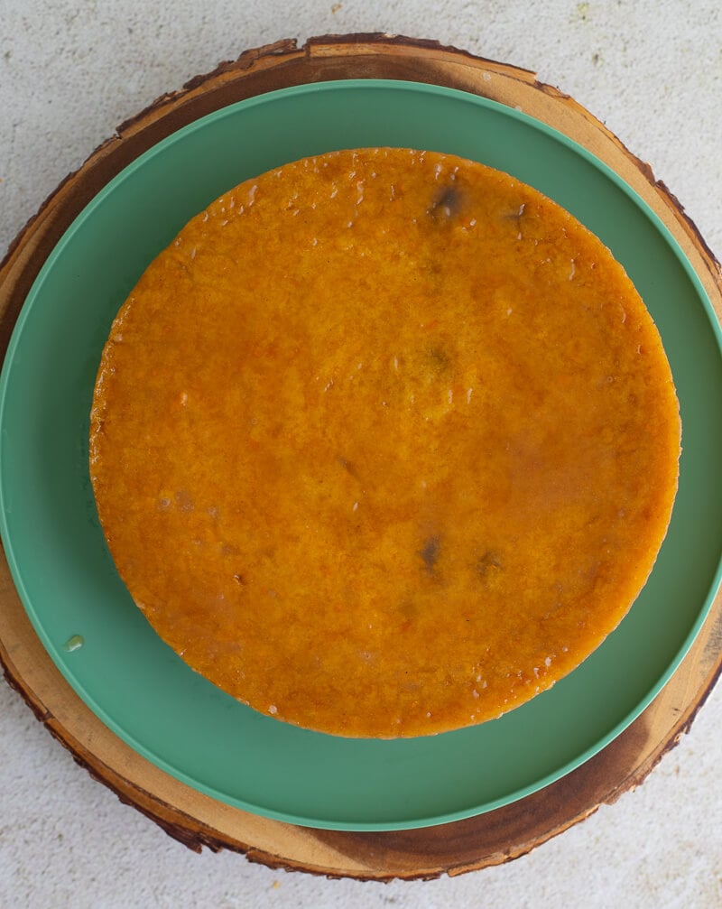 Whole baked pone on a green plate, with a glossy golden soft top and rich color from pumpkin.
