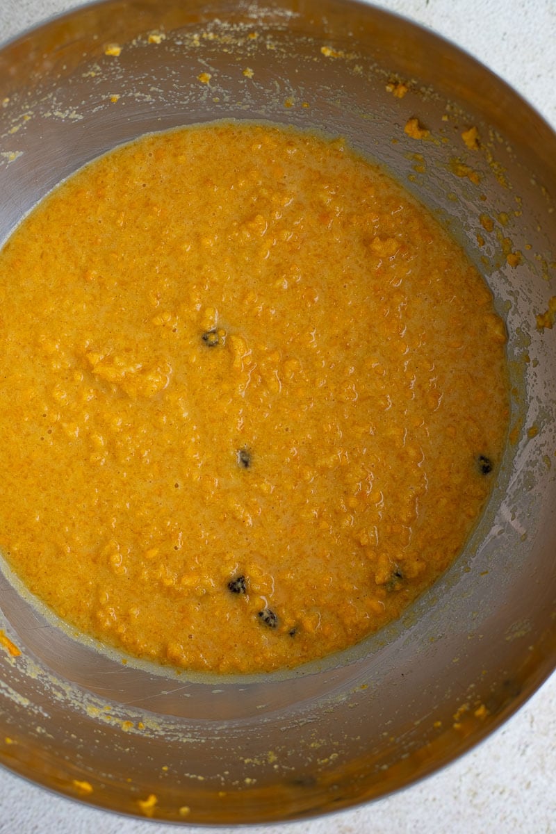 Cornmeal pone batter mixed with coconut milk and dotted with raisins, ready to pour into the baking pan