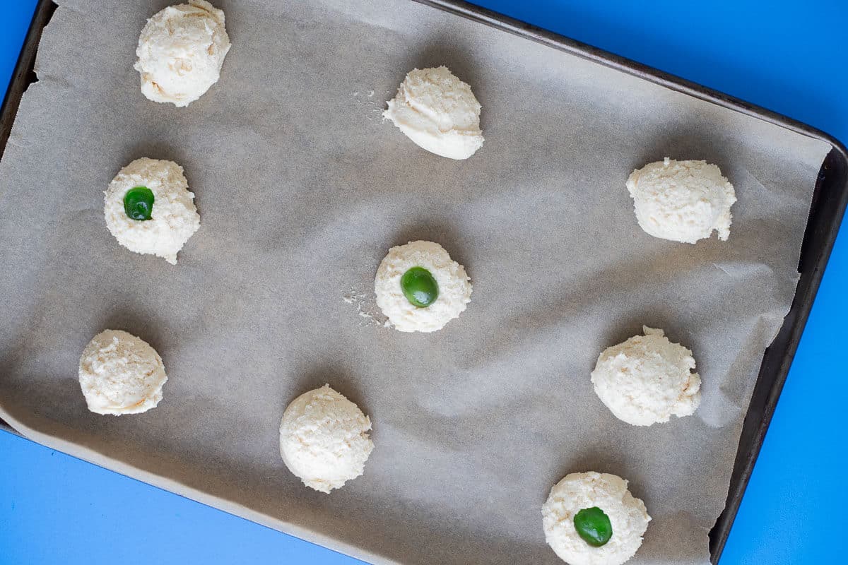 Scooped cassava flour cookie dough on a parchment-lined baking sheet before baking