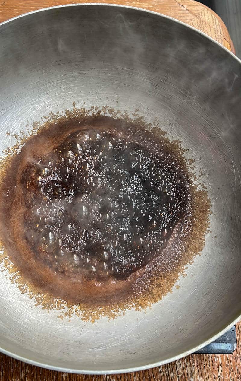 Caramelized sugar bubbling in a pot at the perfect stage before adding meat for stewing.