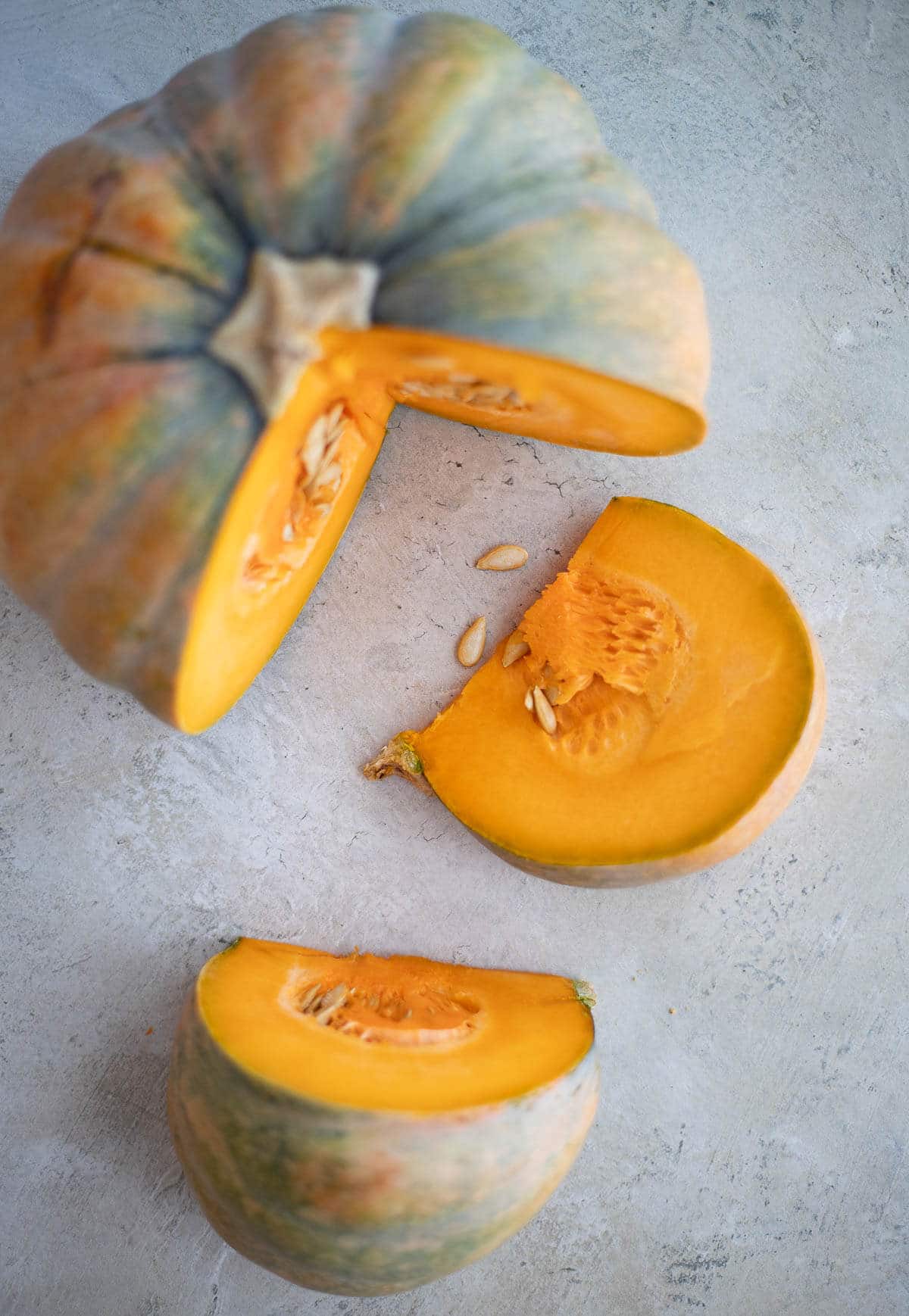 Calabaza pumpkin cut into wedges showing bright orange flesh used in Caribbean cooking.
