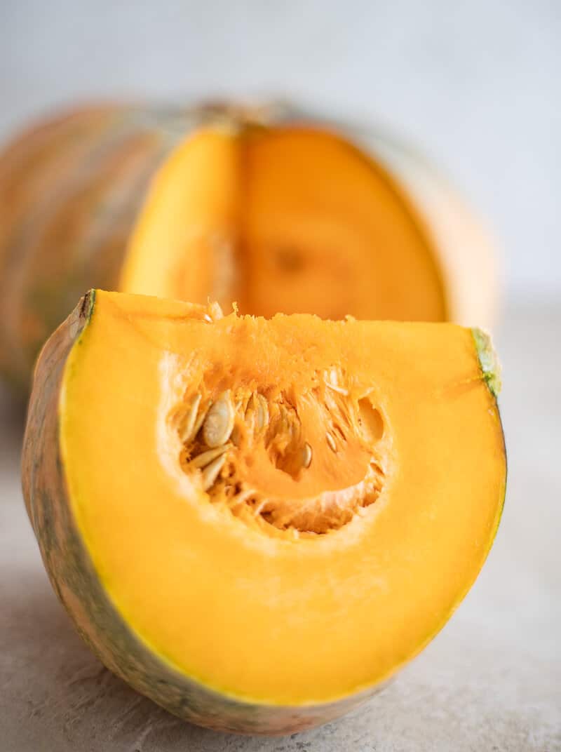 Close-up of calabaza pumpkin showing dense orange flesh and seeds.