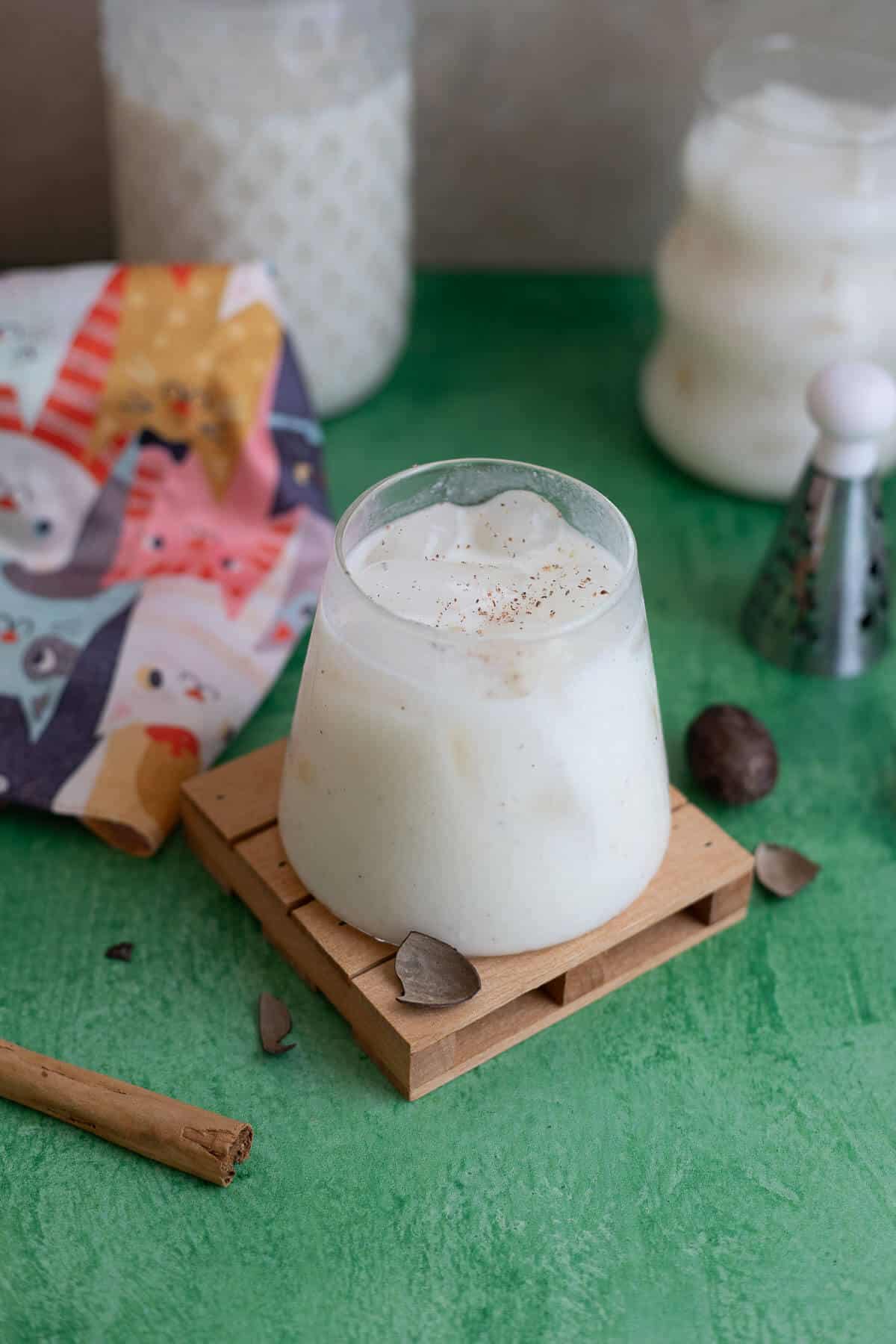 Creamy Caribbean cassava smoothie in a glass, topped with cinnamon and served on a wooden coaster