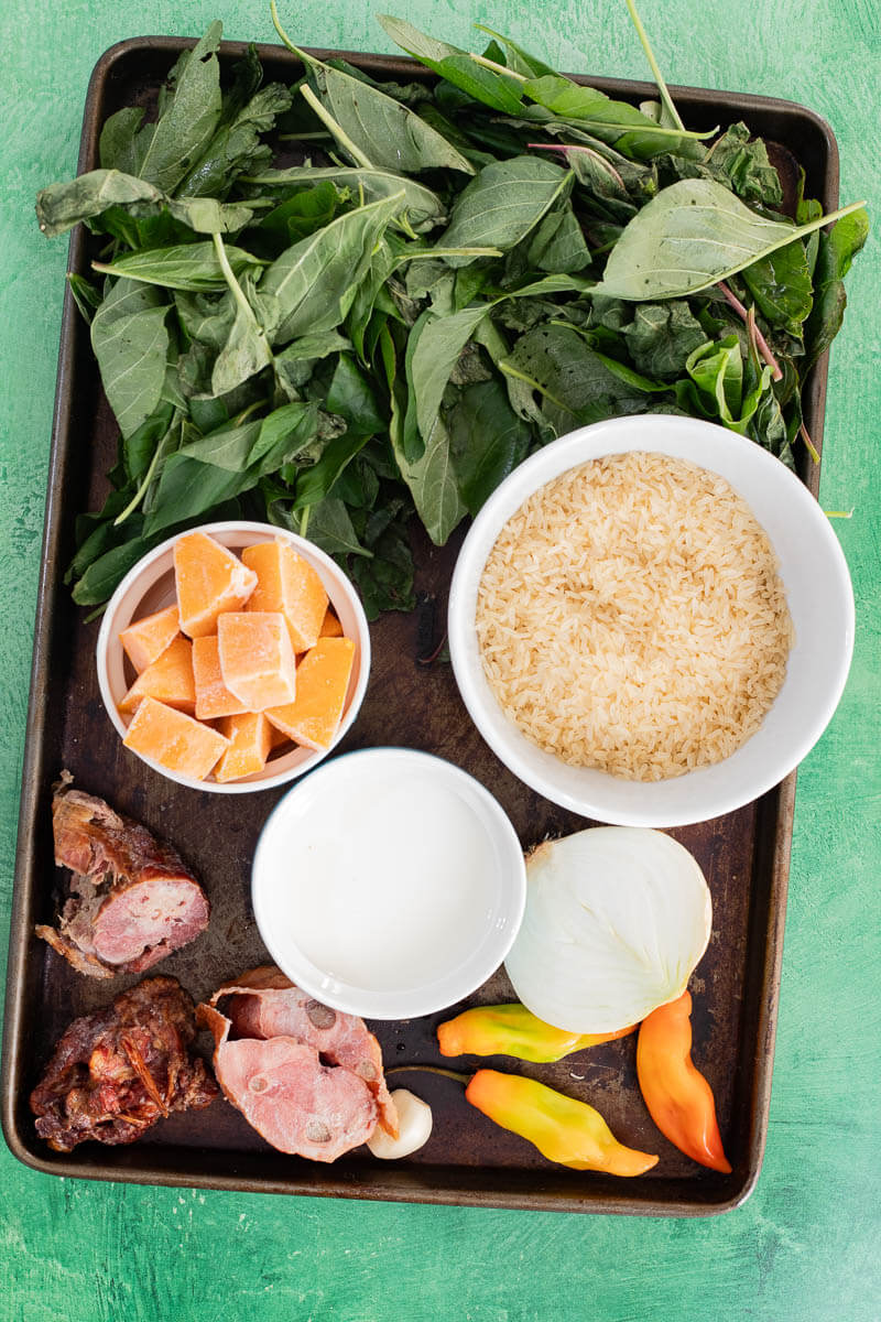 Ingredients including bhaji leaves, rice, pumpkin, onion, pimento peppers, and smoked meat