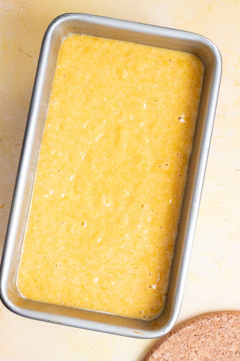 Mango bread batter poured into a loaf pan before baking