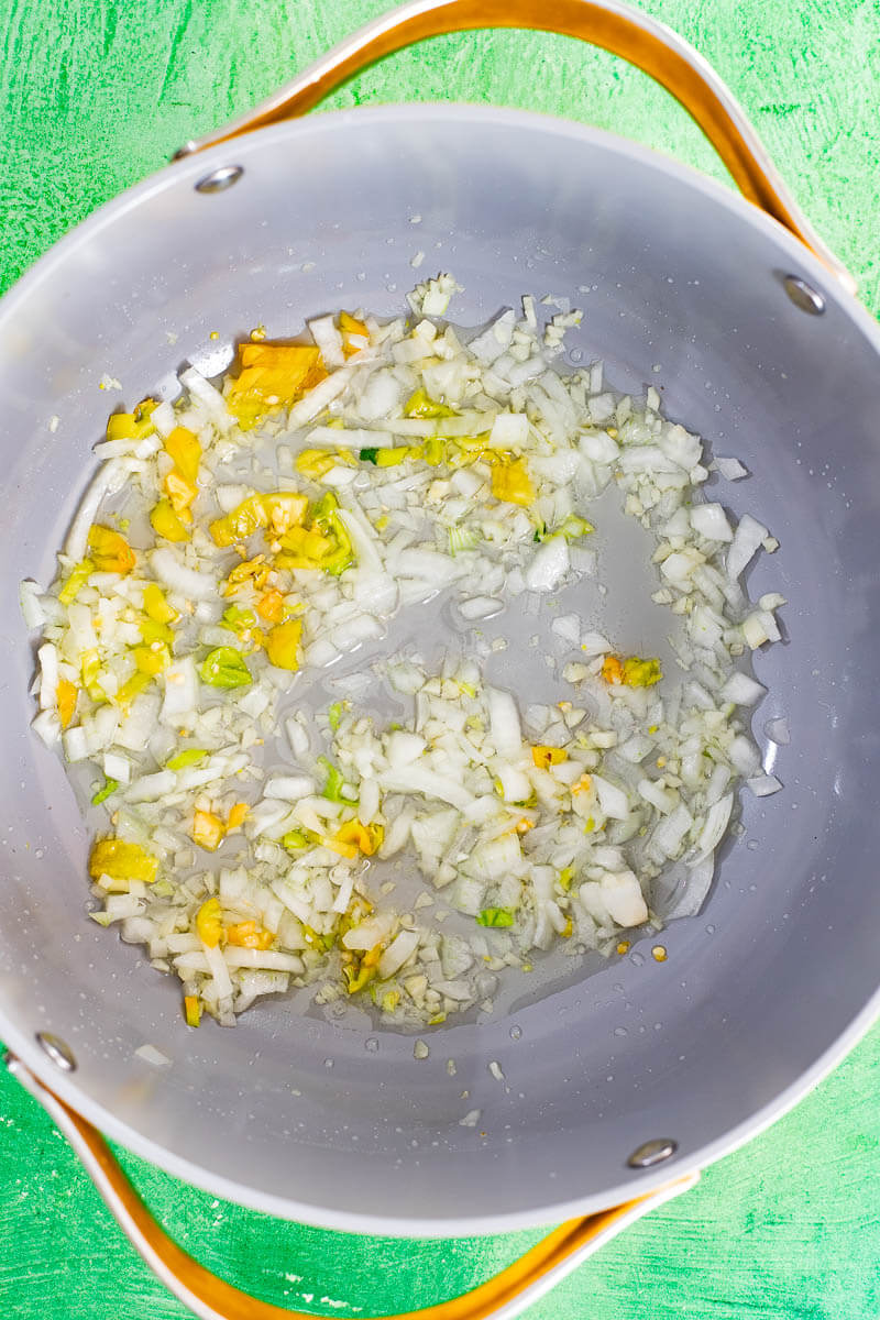 Onion, garlic, and pimento peppers sautéing in a pot