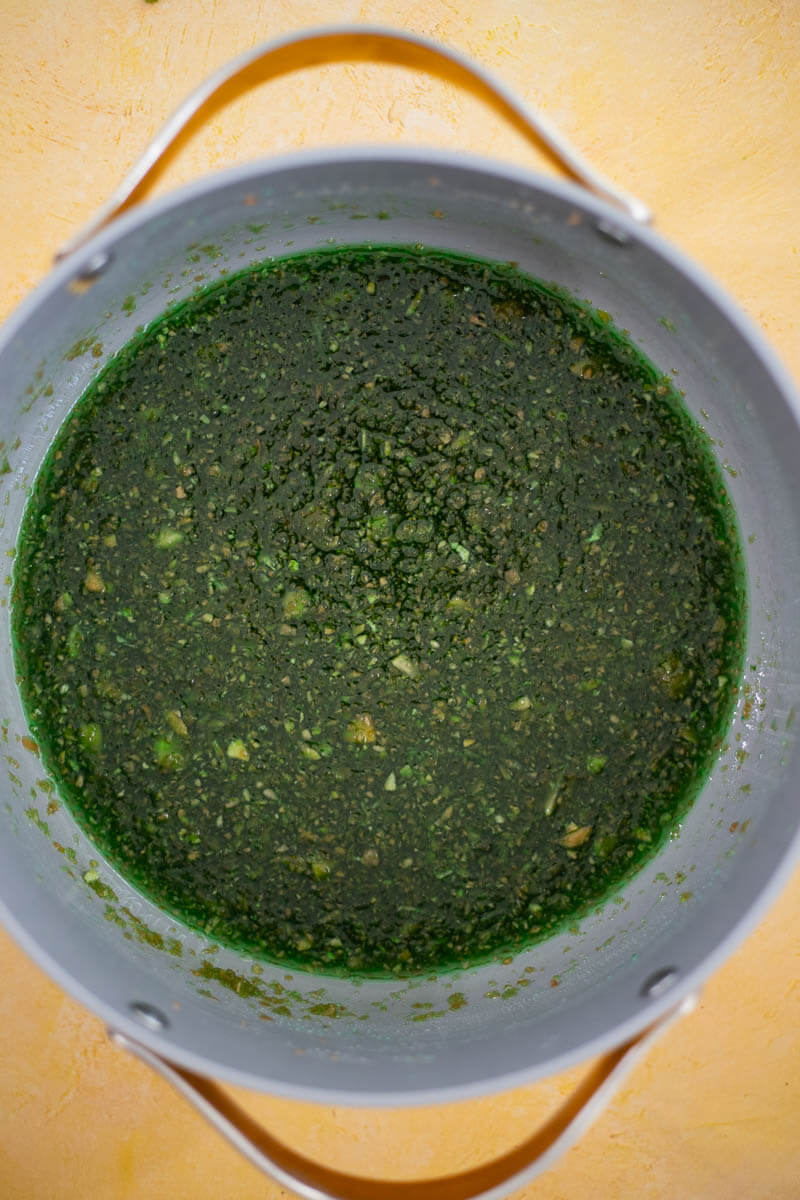 Paw paw ball mixture cooking in a pot with green food coloring