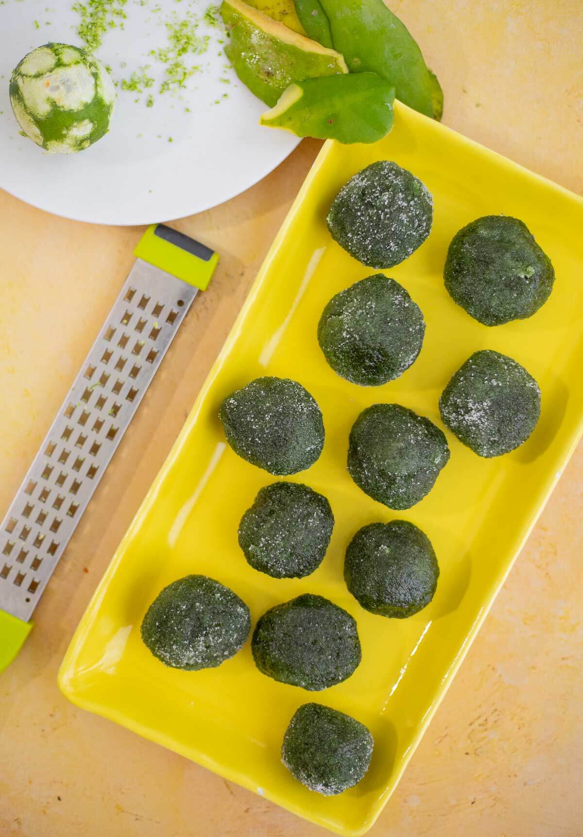 Trinidad paw paw balls rolled in sugar on a yellow serving tray