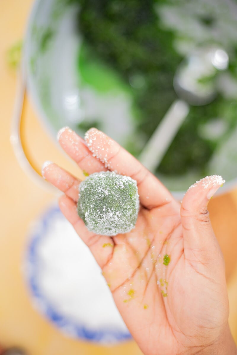 Rolling homemade paw paw balls in granulated sugar