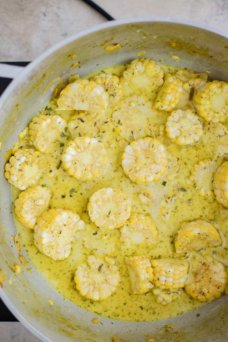 Corn simmering in coconut milk and water with curry and herbs.
