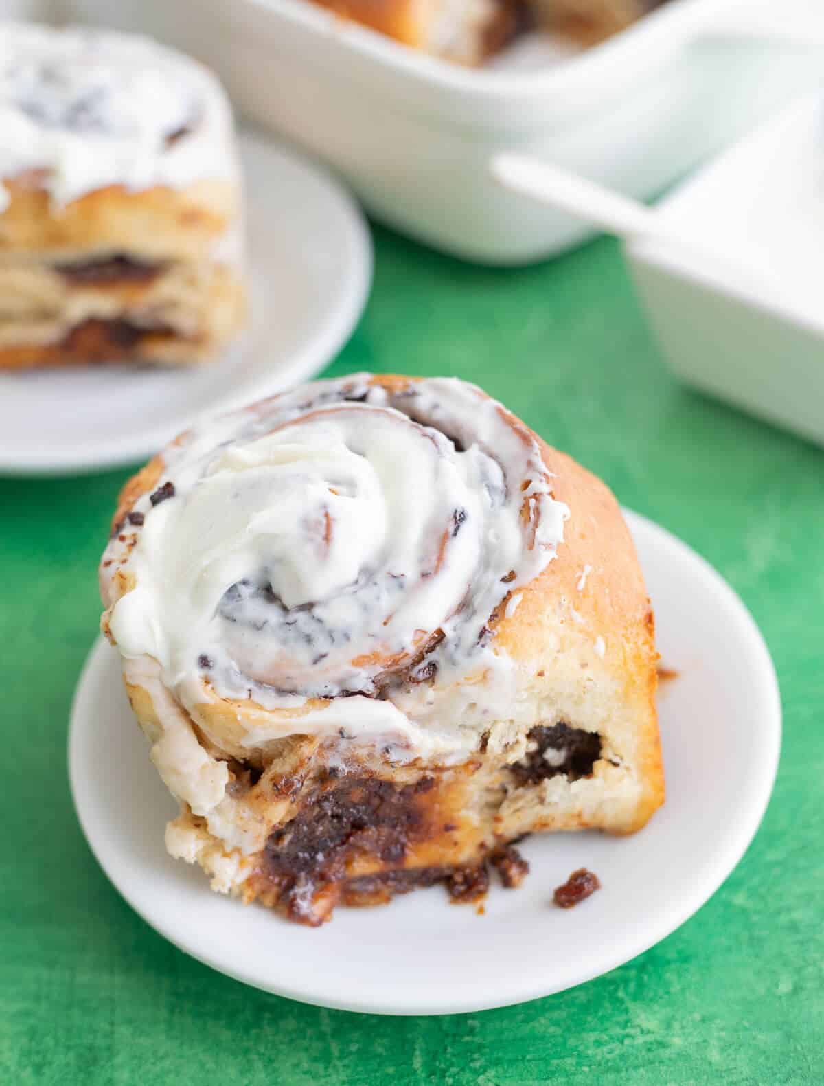 Inside of a soft cinnamon roll showing the thick black cake soaked fruit filling