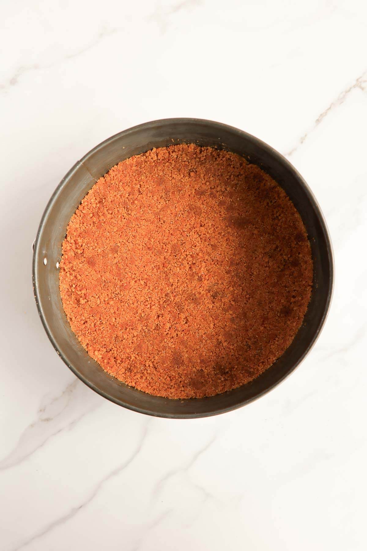 Gingersnap crust pressed into a springform pan.