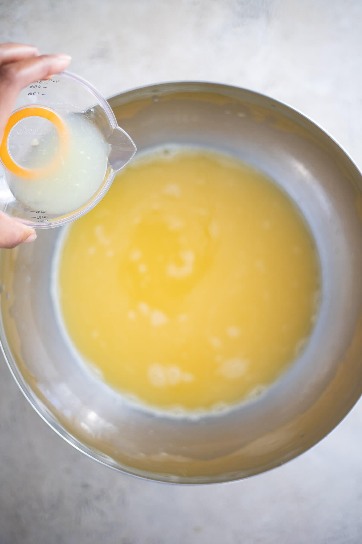 Freshly squeezed lime juice being poured into a bowl of homemade star fruit juice.