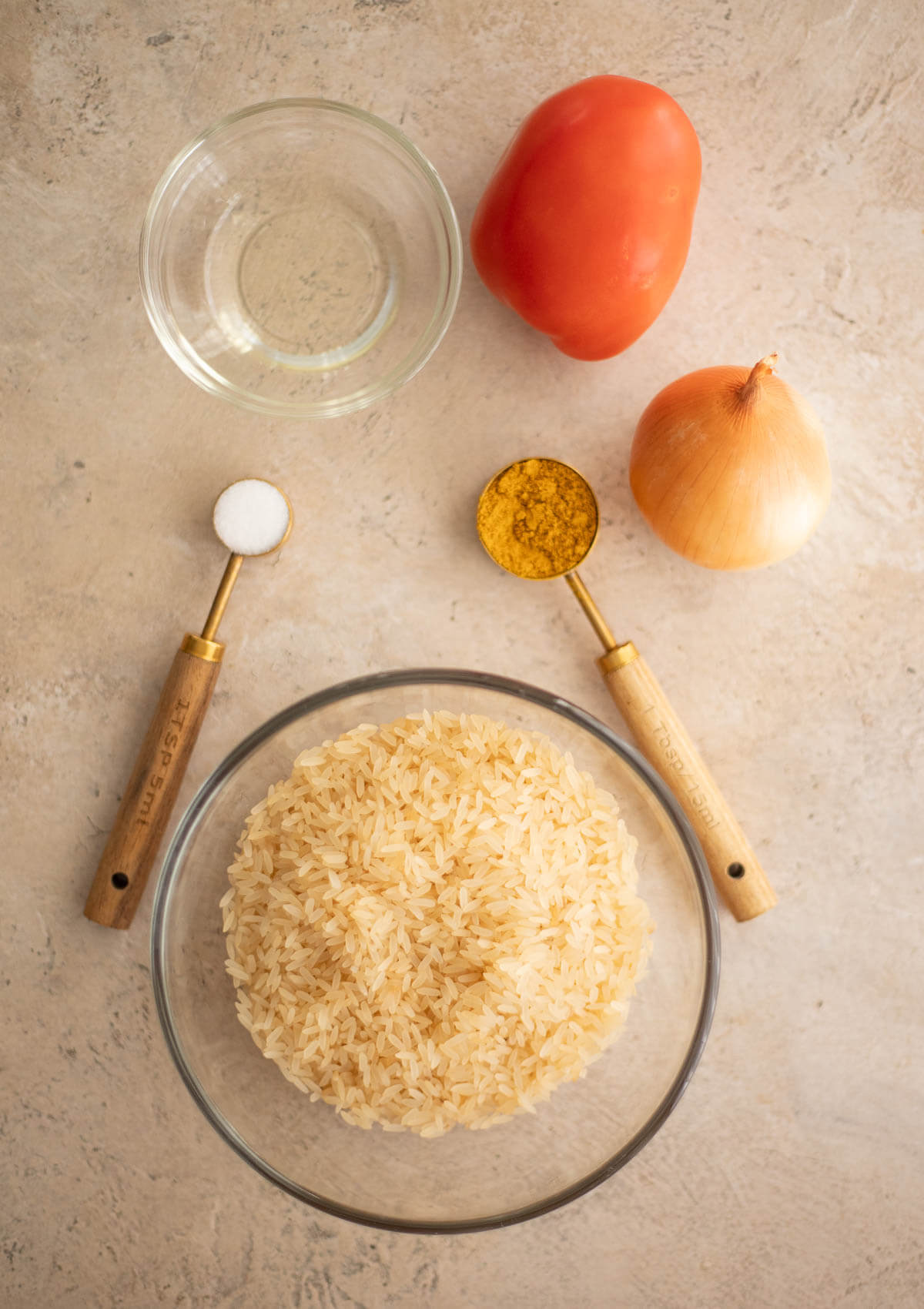 Ingredients for Caribbean curried rice, including parboiled rice, curry powder, onion, tomato, oil, and salt.