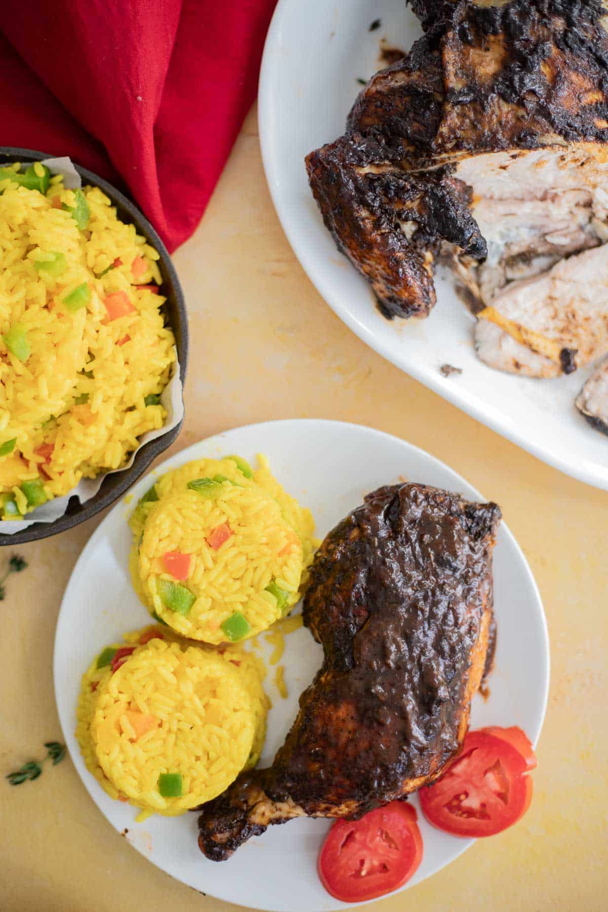 Slices of oven baked jerk chicken served with Caribbean yellow rice.