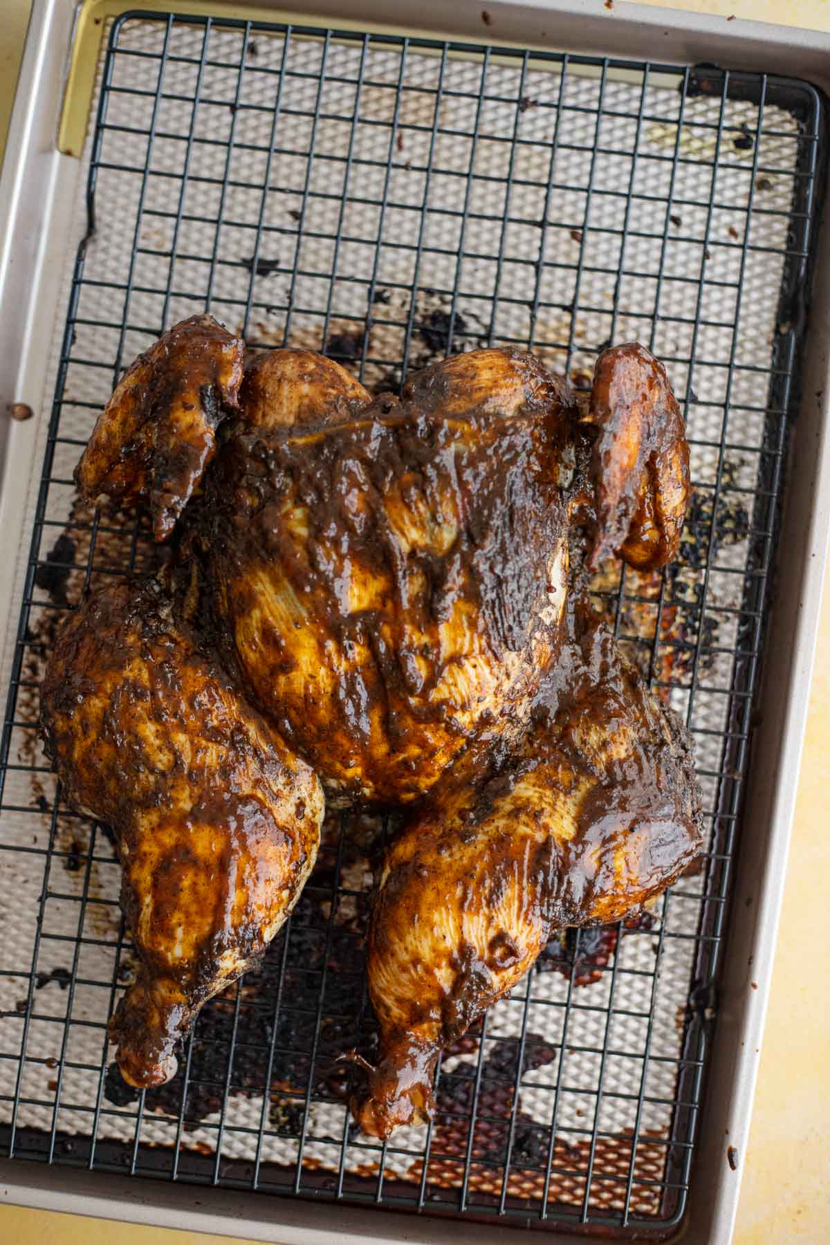 Oven roasted spatchcocked jerk chicken with a dark, glossy jerk BBQ glaze.