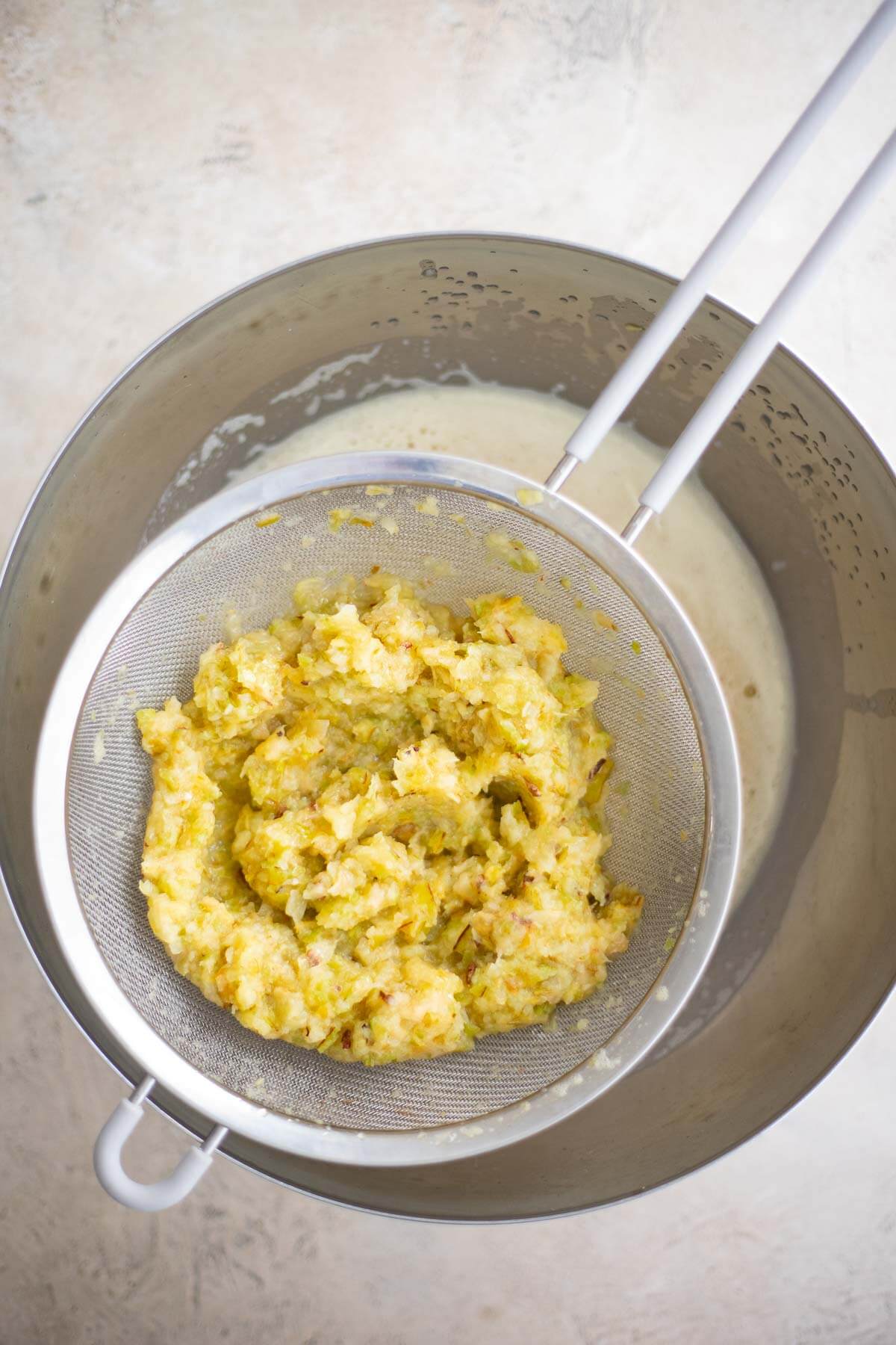 Blended star fruit pulp in a fine-mesh strainer over a bowl of freshly strained juice.